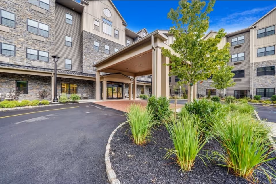 Exterior view of Mercer Hill at Doylestown showing building entrance with covered drop-off and landscaping