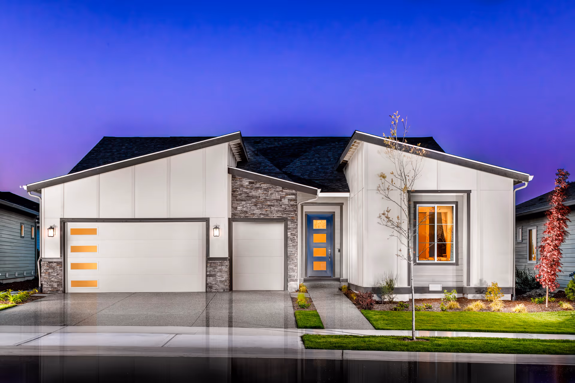 Front view of a modern single-story facility with a two-car garage and landscaped yard.