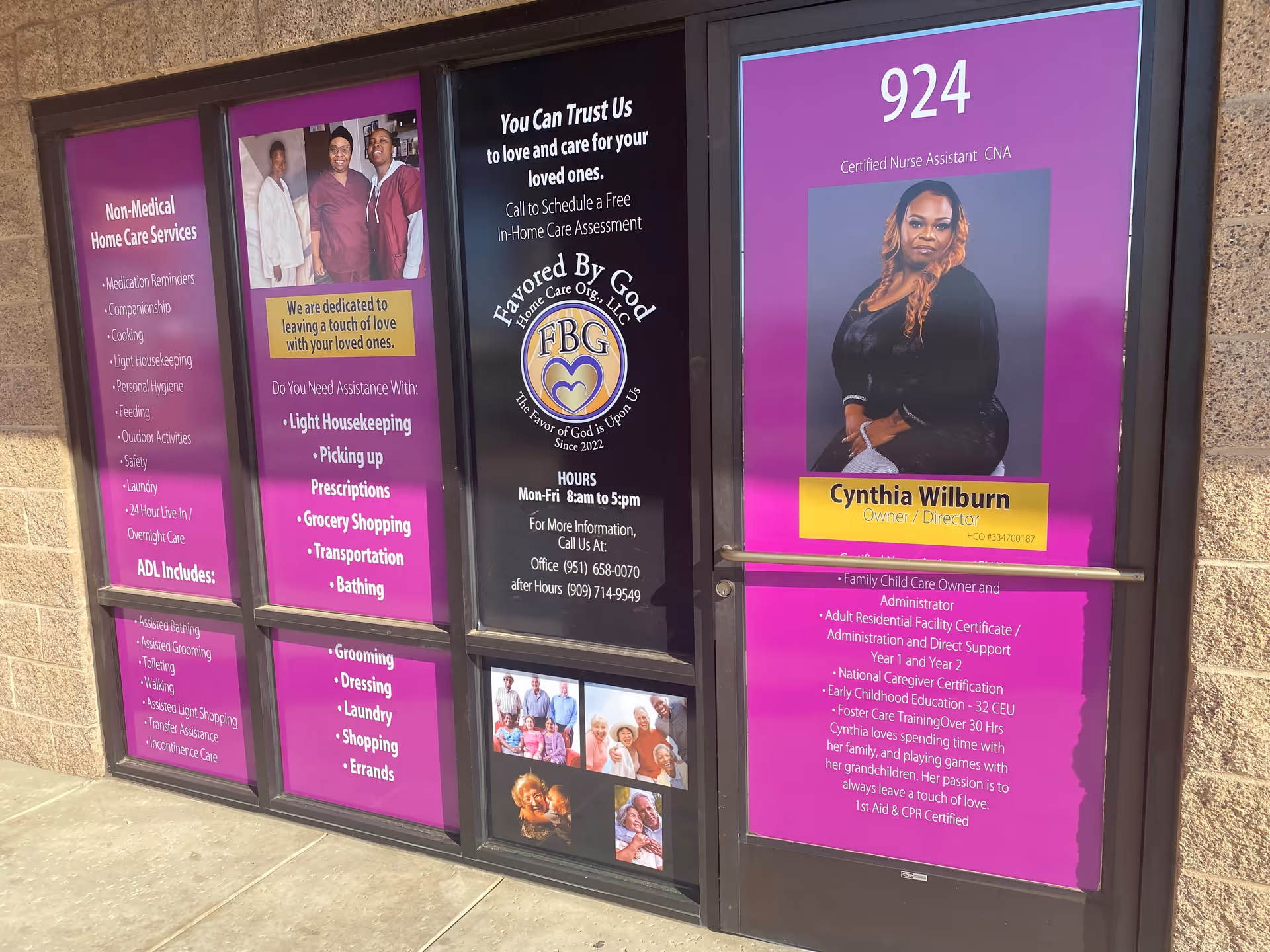 Exterior storefront windows display purple posters advertising Favored By God Home Care services