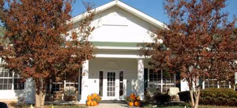Brookdale Pinehurst front entrance with autumn trees and pumpkins.