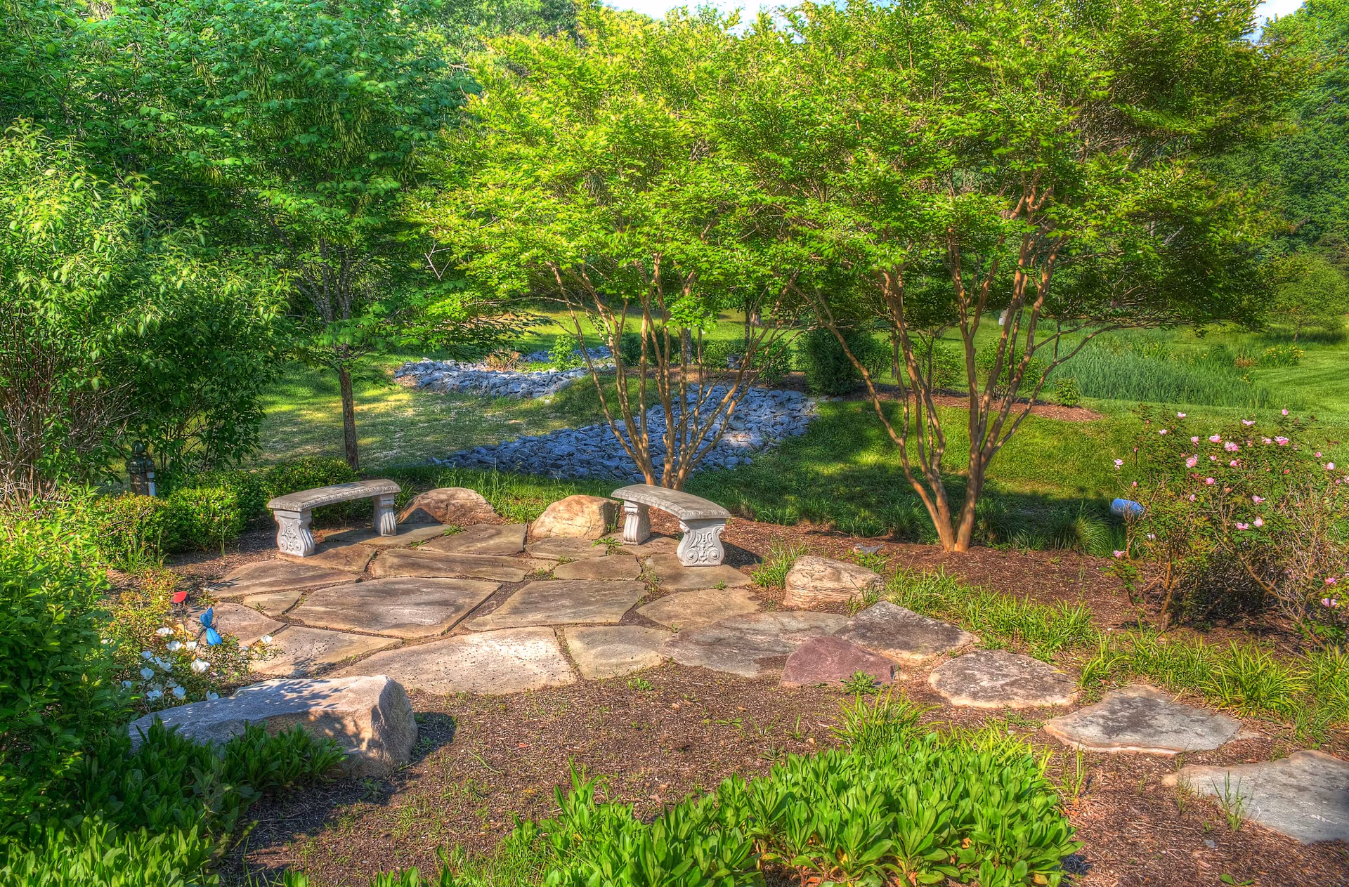 Outdoor garden courtyard with stone benches and landscaped paths.