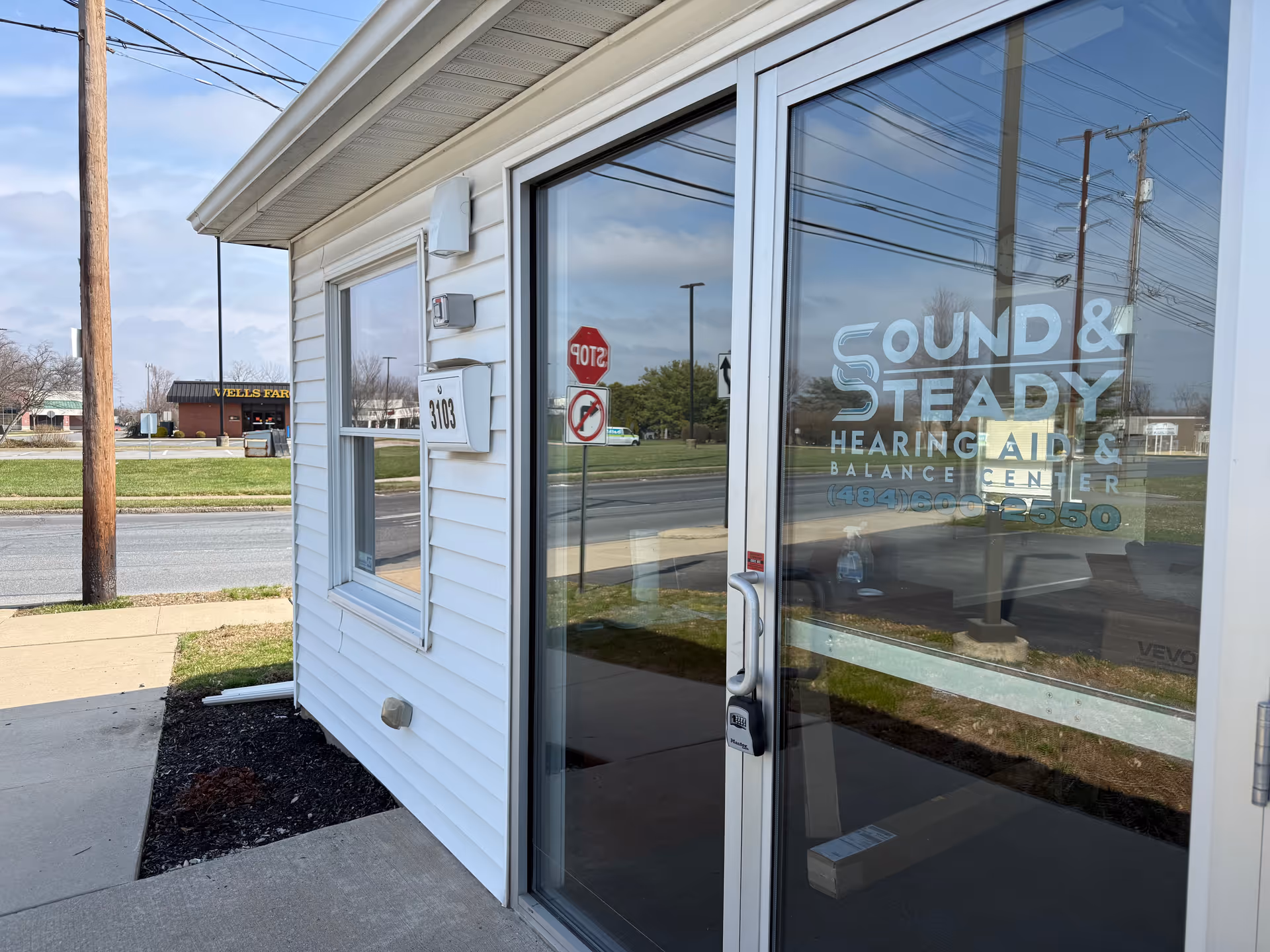 Exterior view of a building front with glass door and Sound & Steady signage.