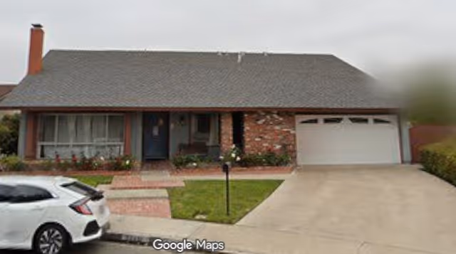 Front view of a single-story brick house with a two-car garage and parked car.