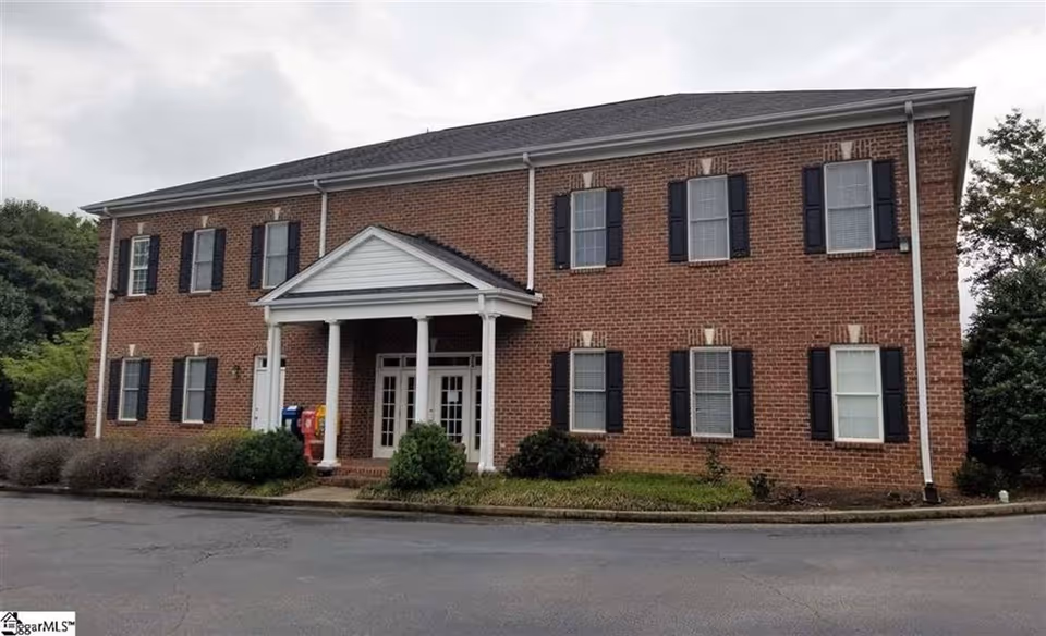 Brick two-story senior living building with a covered front entrance.