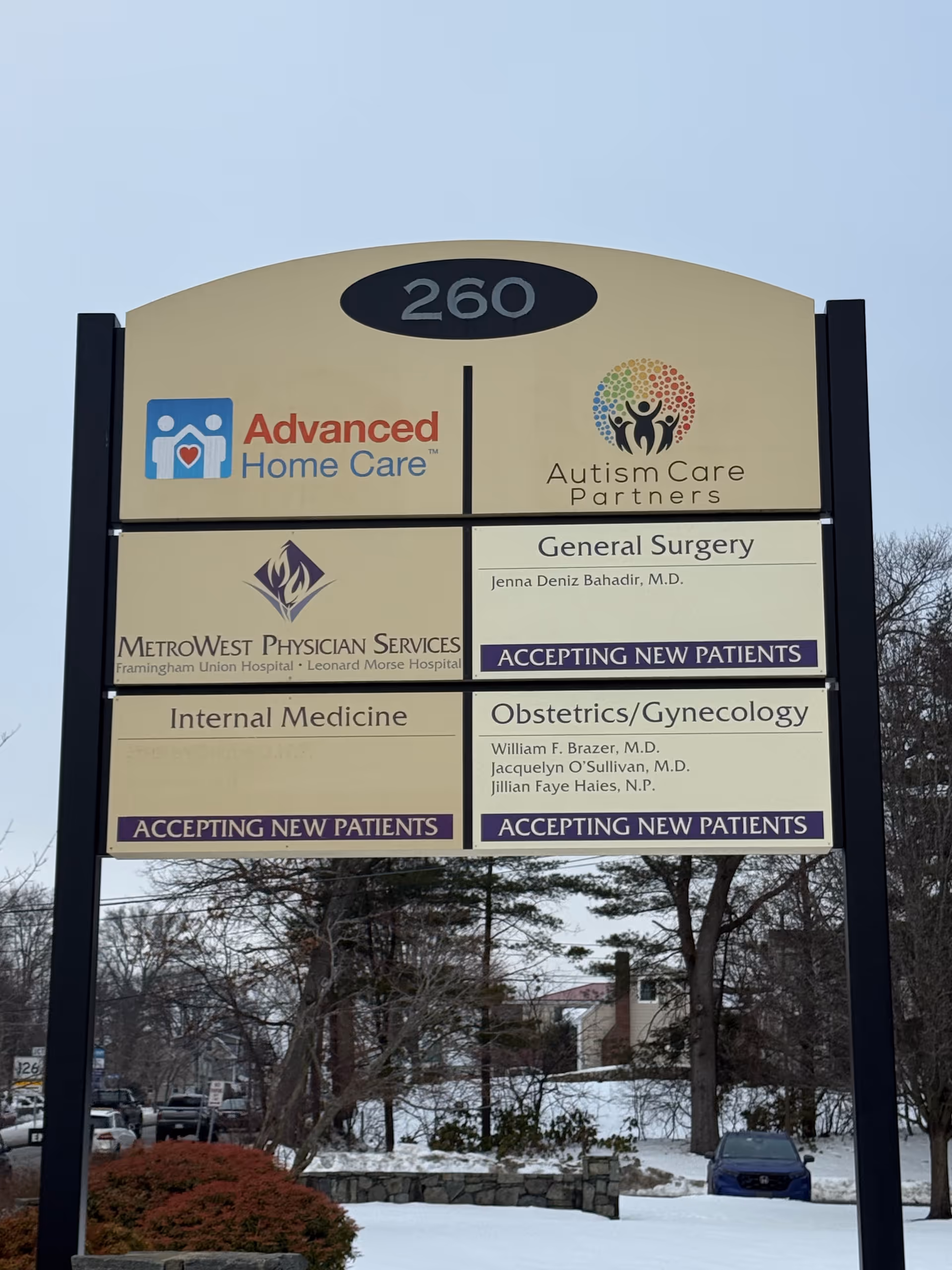 Outdoor signboard shows Advanced Home Care logo and other tenant names at a street site.