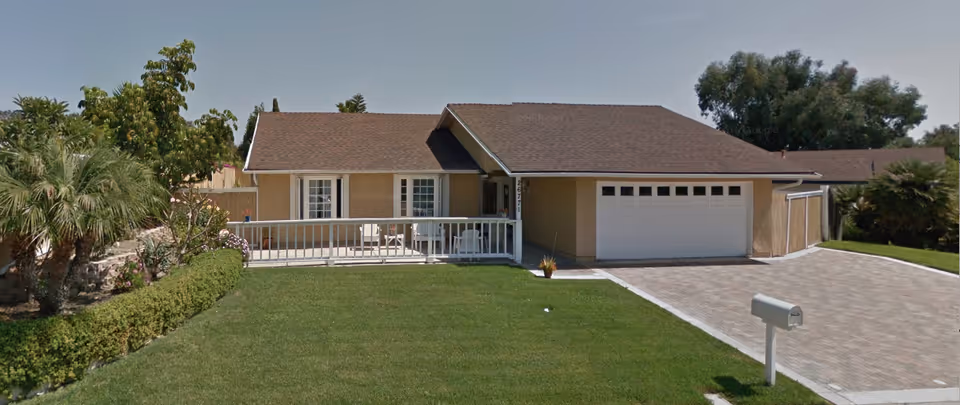 Front exterior of a single-story home with a two-car garage and manicured lawn.