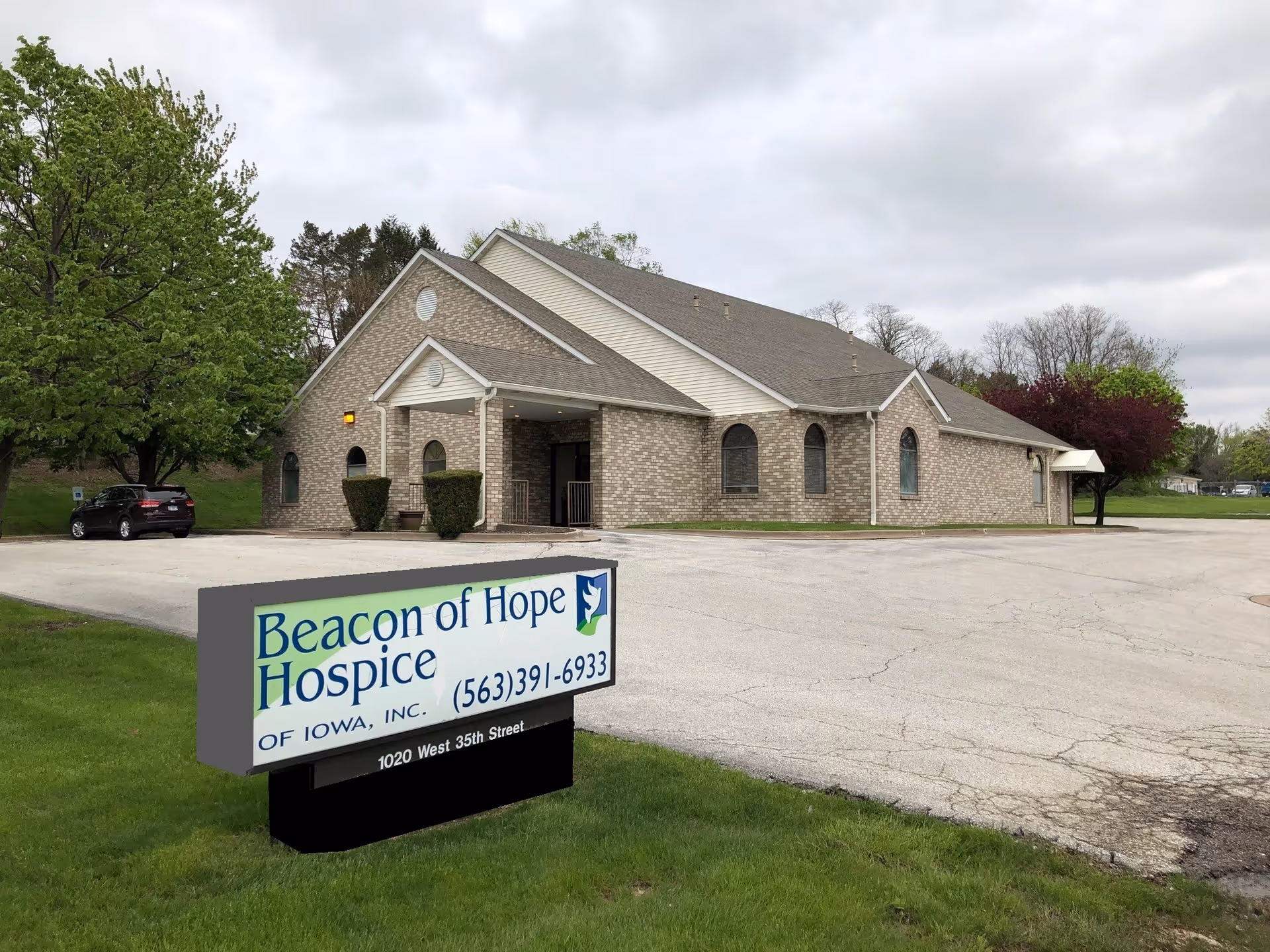 Brick building with peaked roof and a sign reading Beacon of Hope Hospice of Iowa.