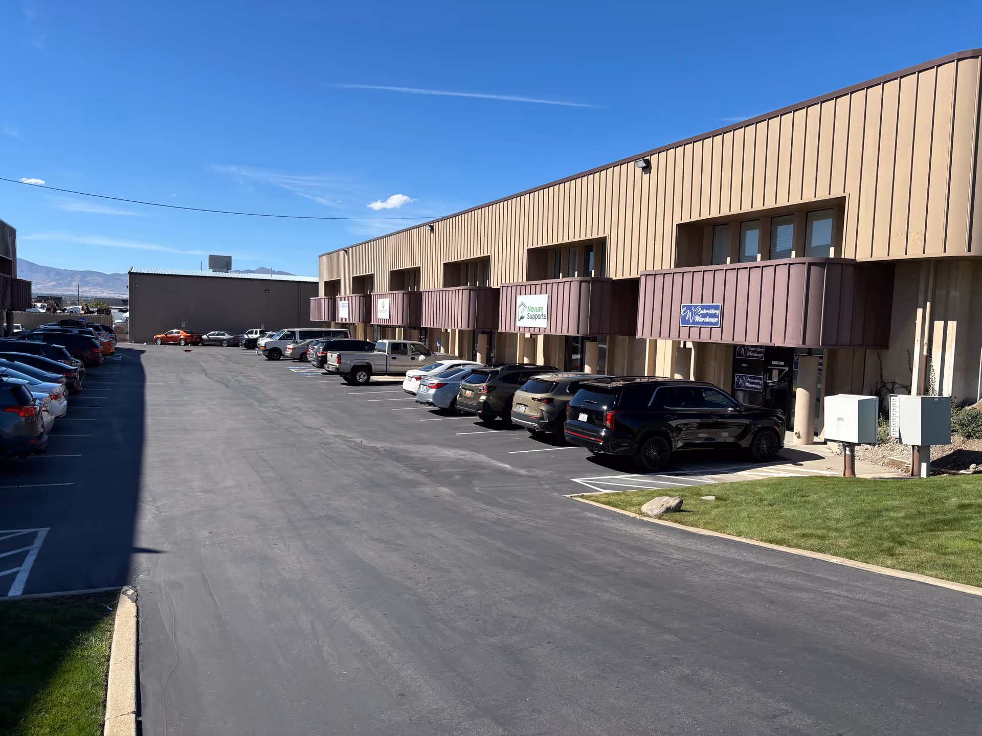 Parking lot in front of a beige senior living facility with balconies.