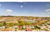 Aerial view of a suburban townscape with houses and greenery.