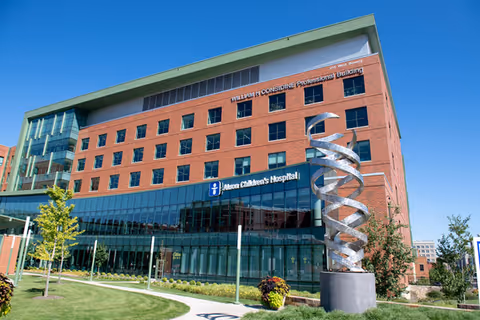 Exterior view of Akron Children's Hospital with a spiral sculpture in front.