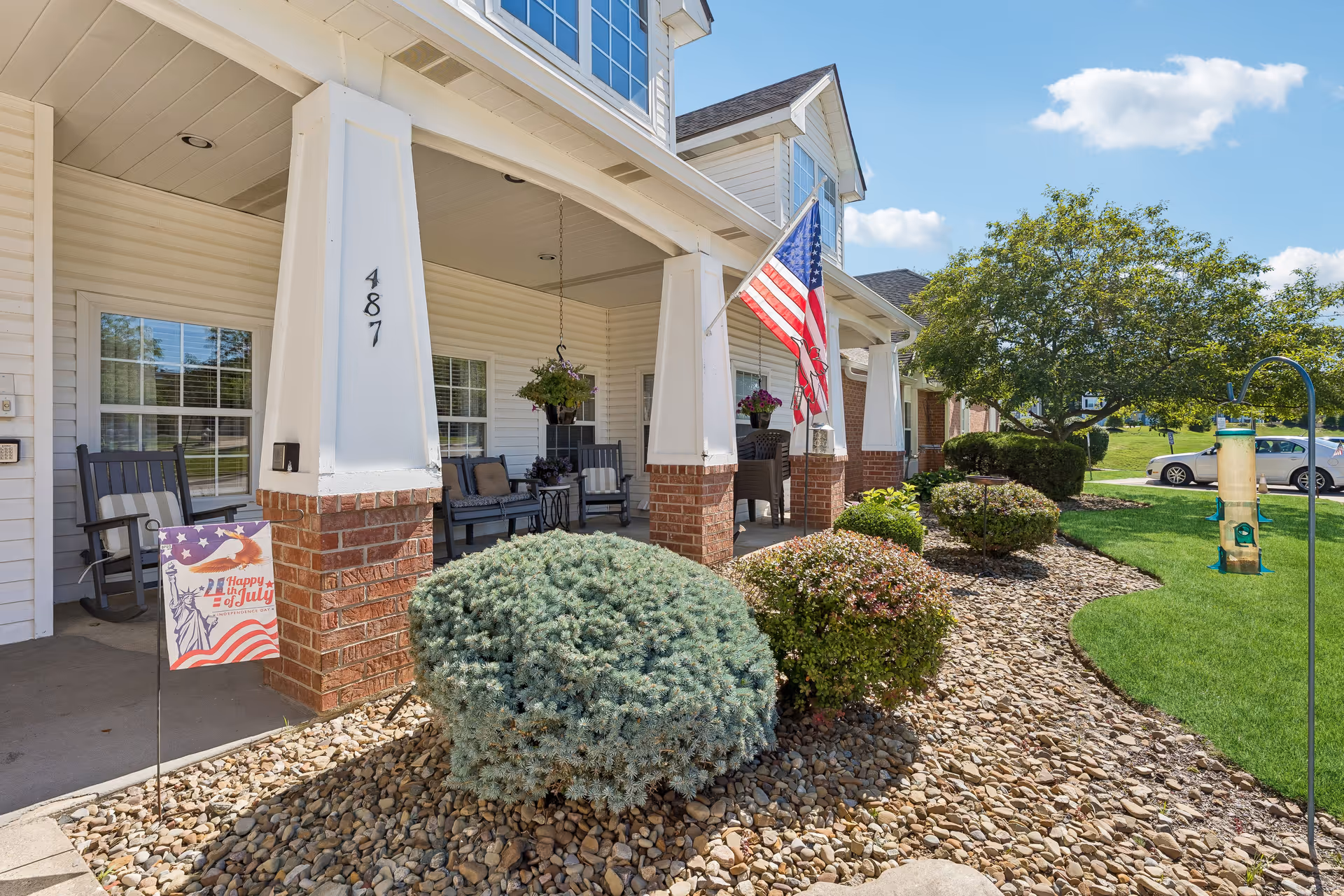 Brookdale Barberton front porch with seating, flag, and landscaped shrubs