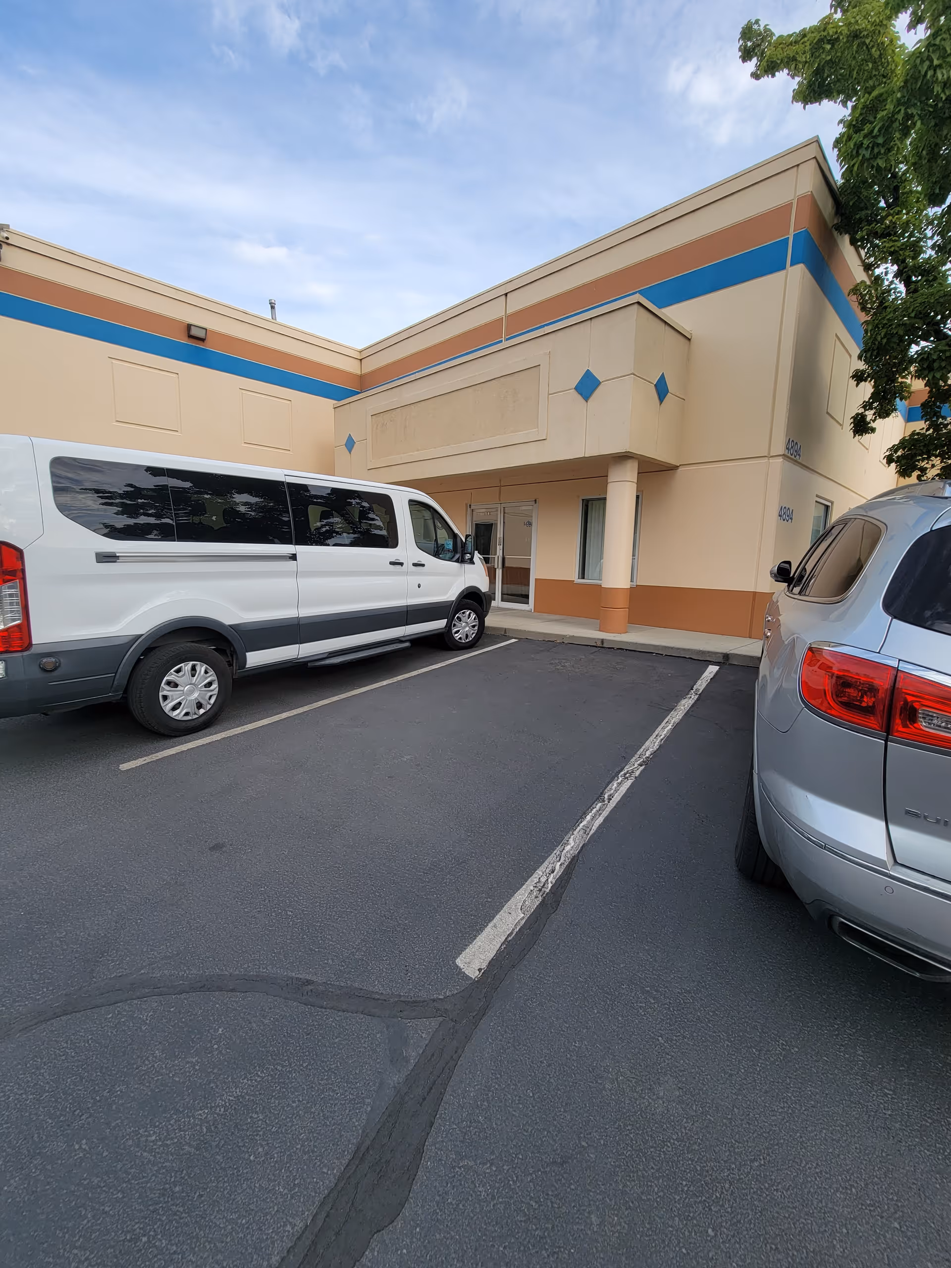 Exterior view of HomeStrength Llc facility with a white van and a silver SUV in parking.