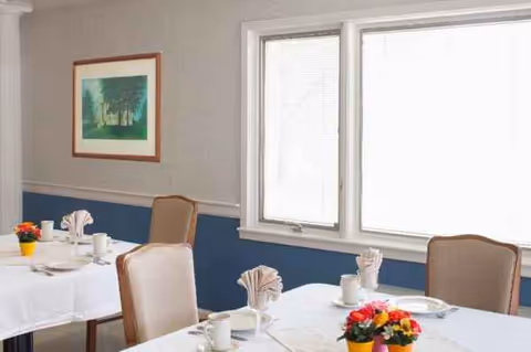 Dining room at Countryside Center for Rehabilitation and Nursing with white tablecloths and floral centerpieces.