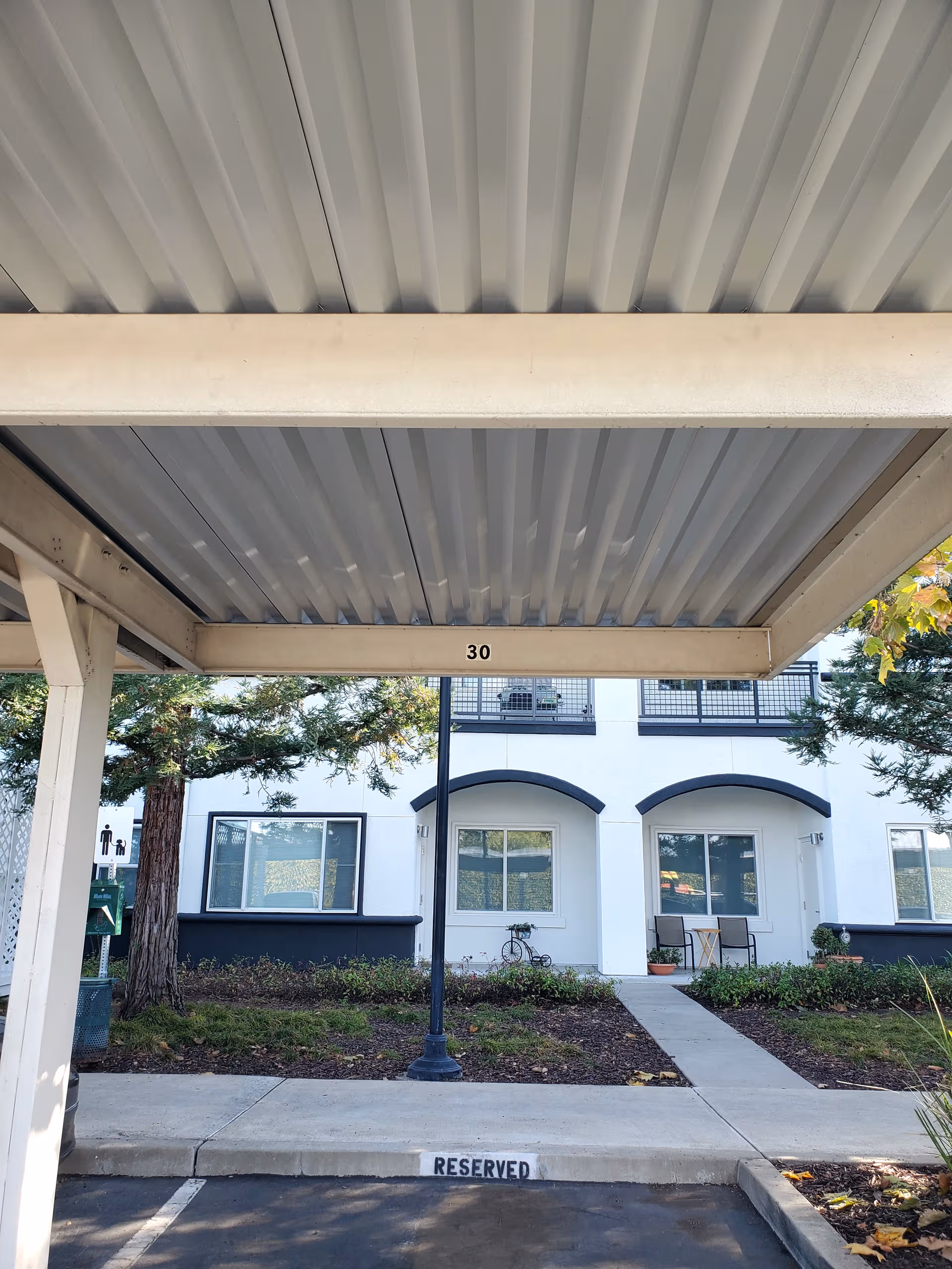 Exterior front of Heritage Estates with a covered entrance, seating area, and landscaping.