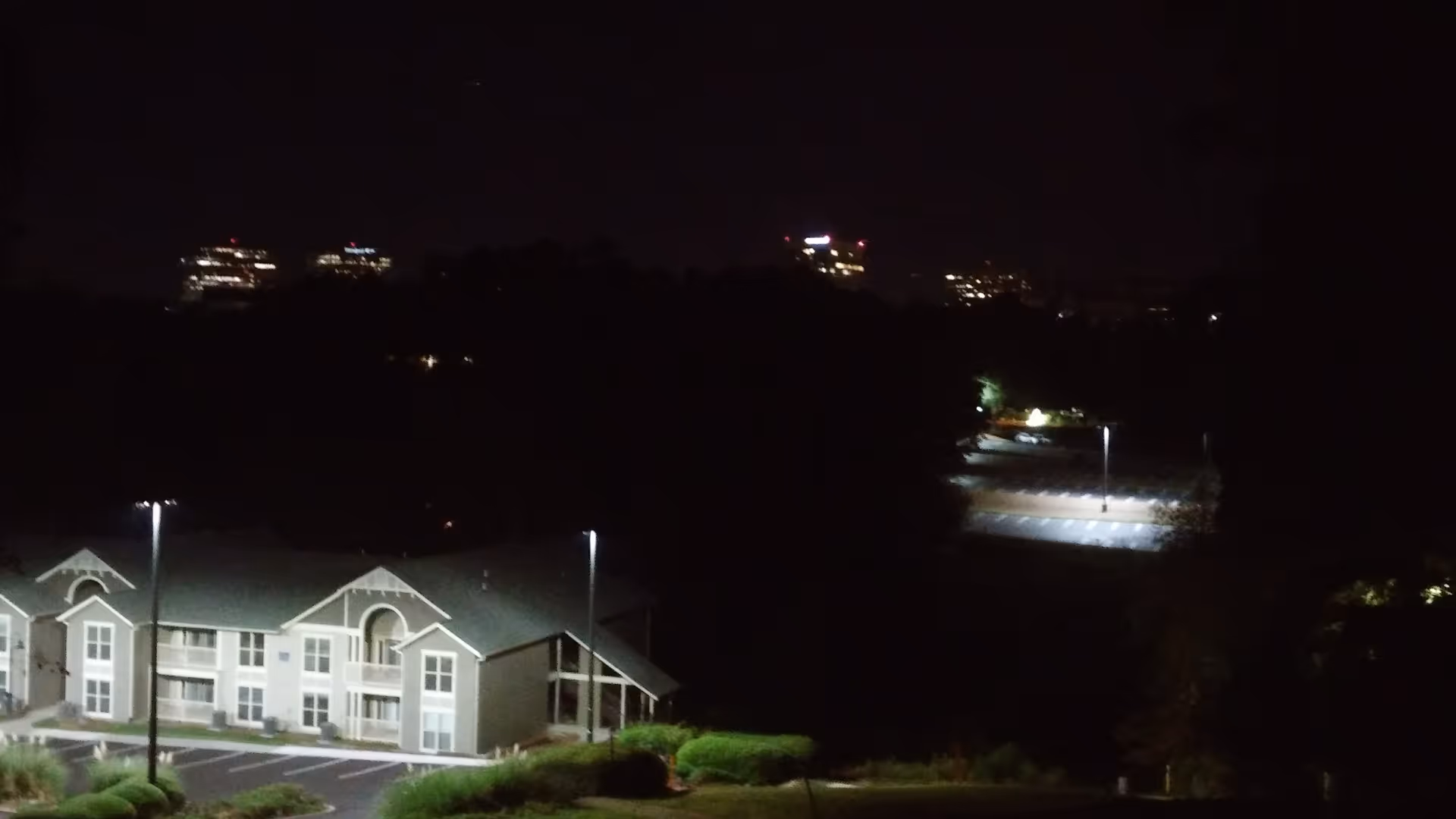 Nighttime exterior view of Avant Care building with lit windows and surrounding parking lot.