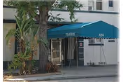 Exterior view of Wirick senior living facility front entrance with a blue canopy and glass doors.