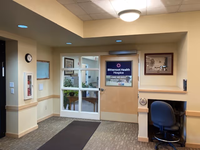 Interior lobby of Bitterroot Health Hospice with glass doors, sign, and seating.