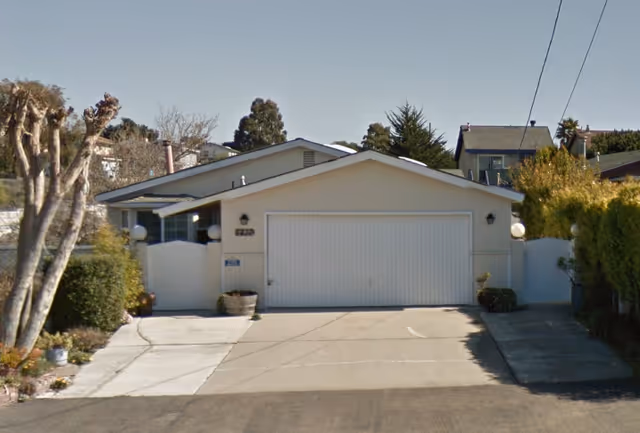 Front view of a single-story building with a two-car garage and driveway.