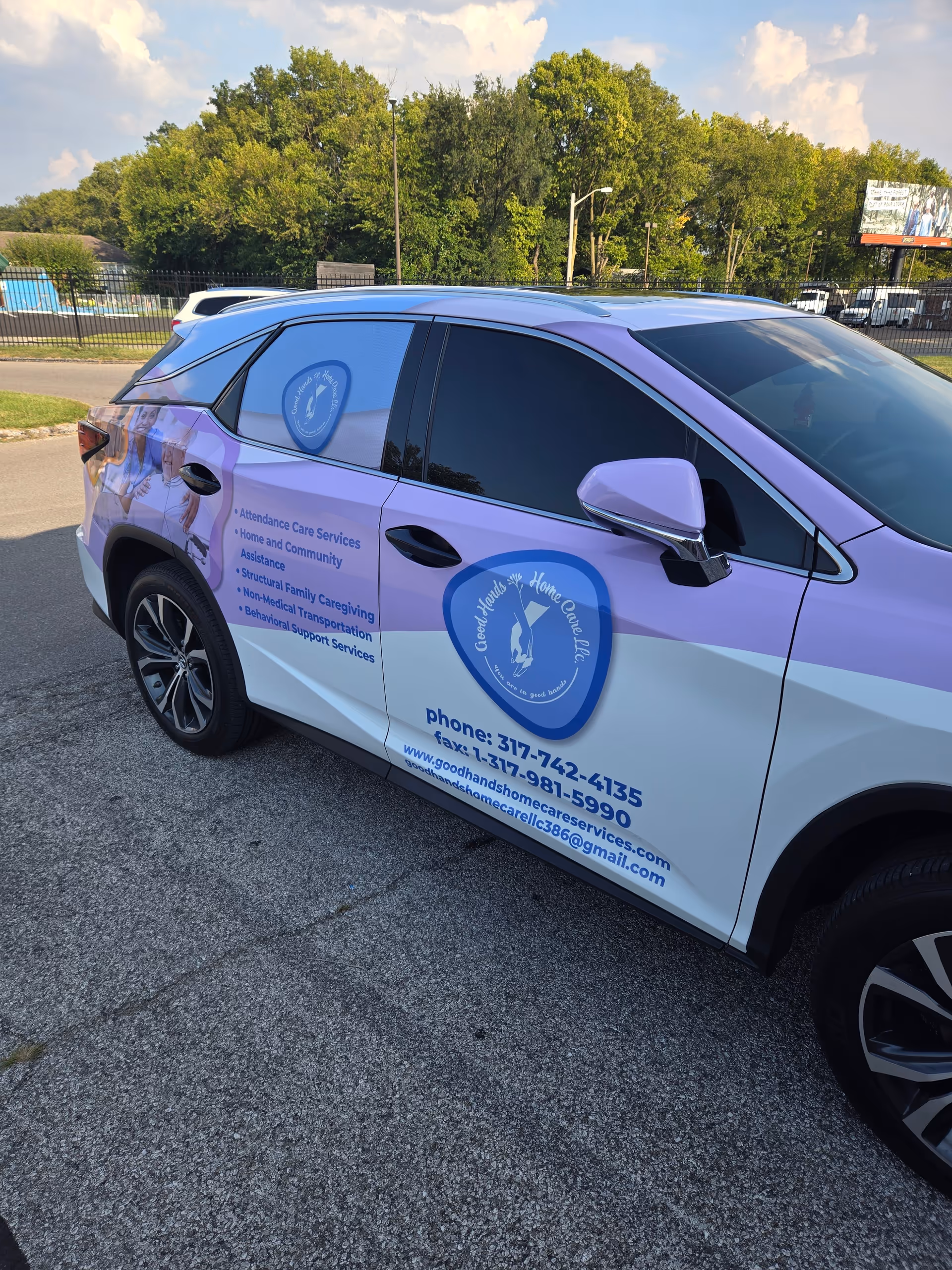 Purple and white branded Good Hands Home Care LLC vehicle parked in a lot.