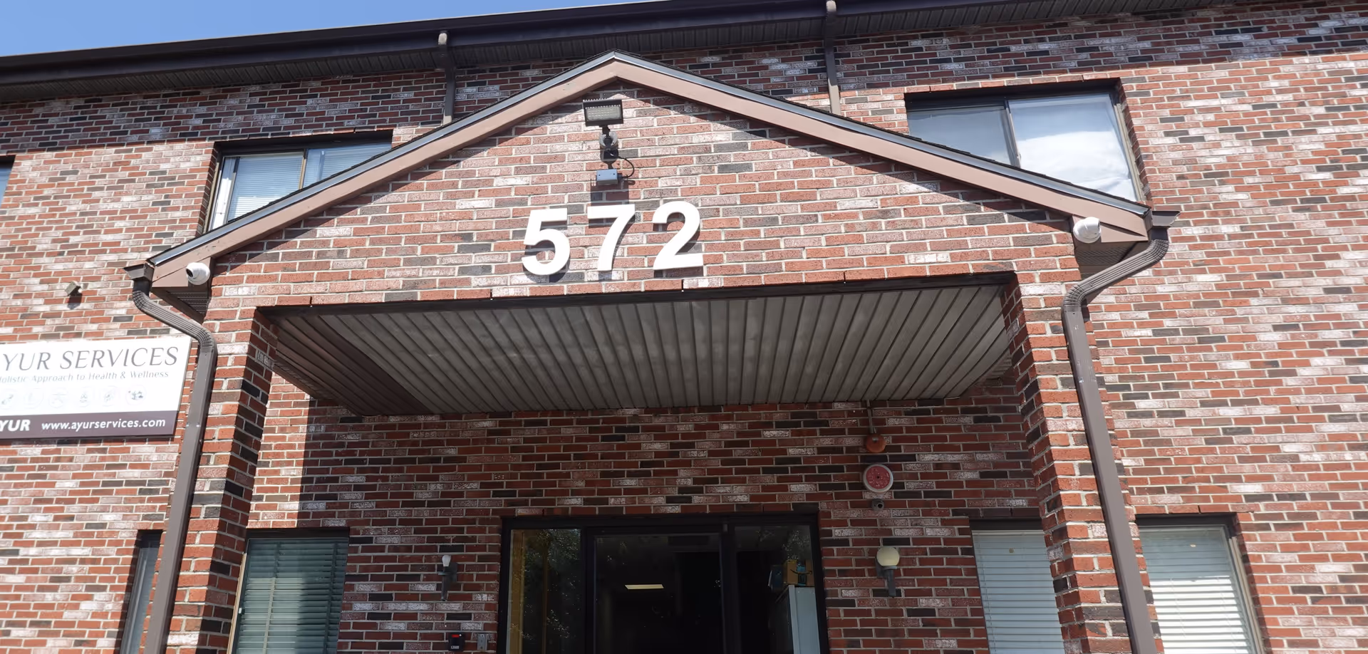 Brick building facade with prominent 572 numbers and an open entrance