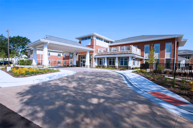 Sunny exterior view of New Summit Rehabilitation and Healthcare building with driveway and entrance canopy.