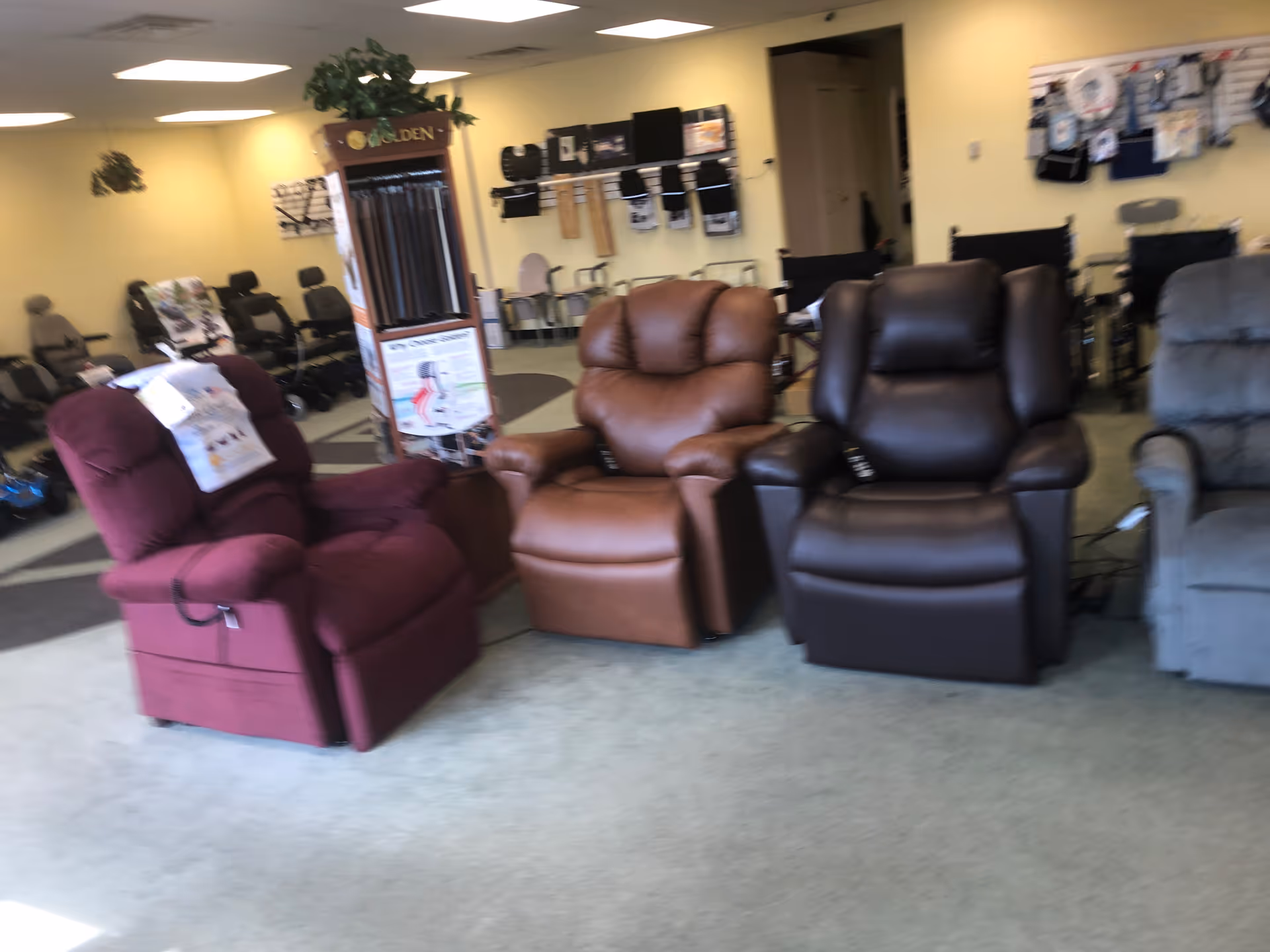 Interior showroom featuring multiple recliner chairs in burgundy, brown, and gray colors.