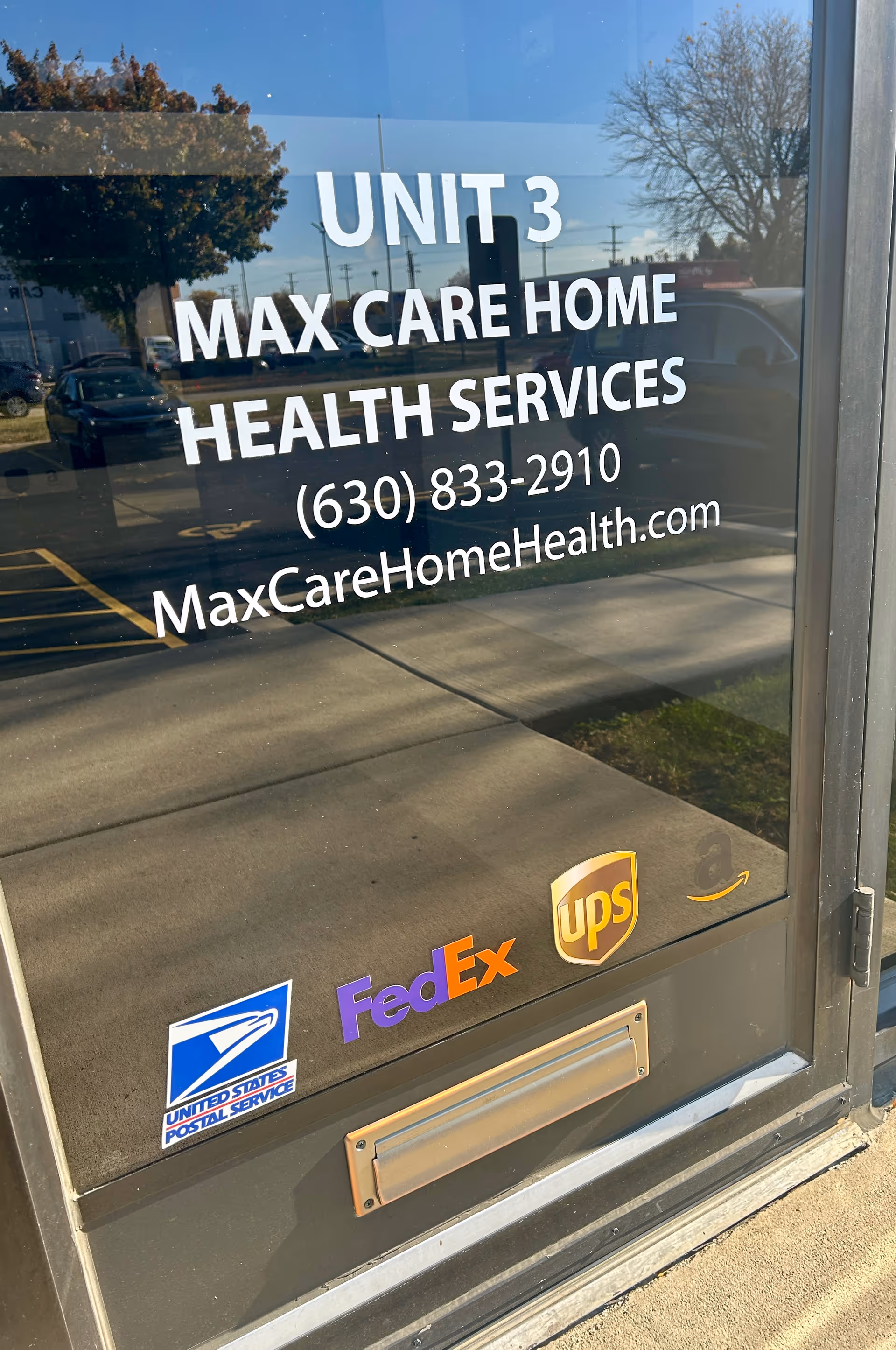 Glass door displays Unit 3 Max Care Home Health Services with carrier logos.