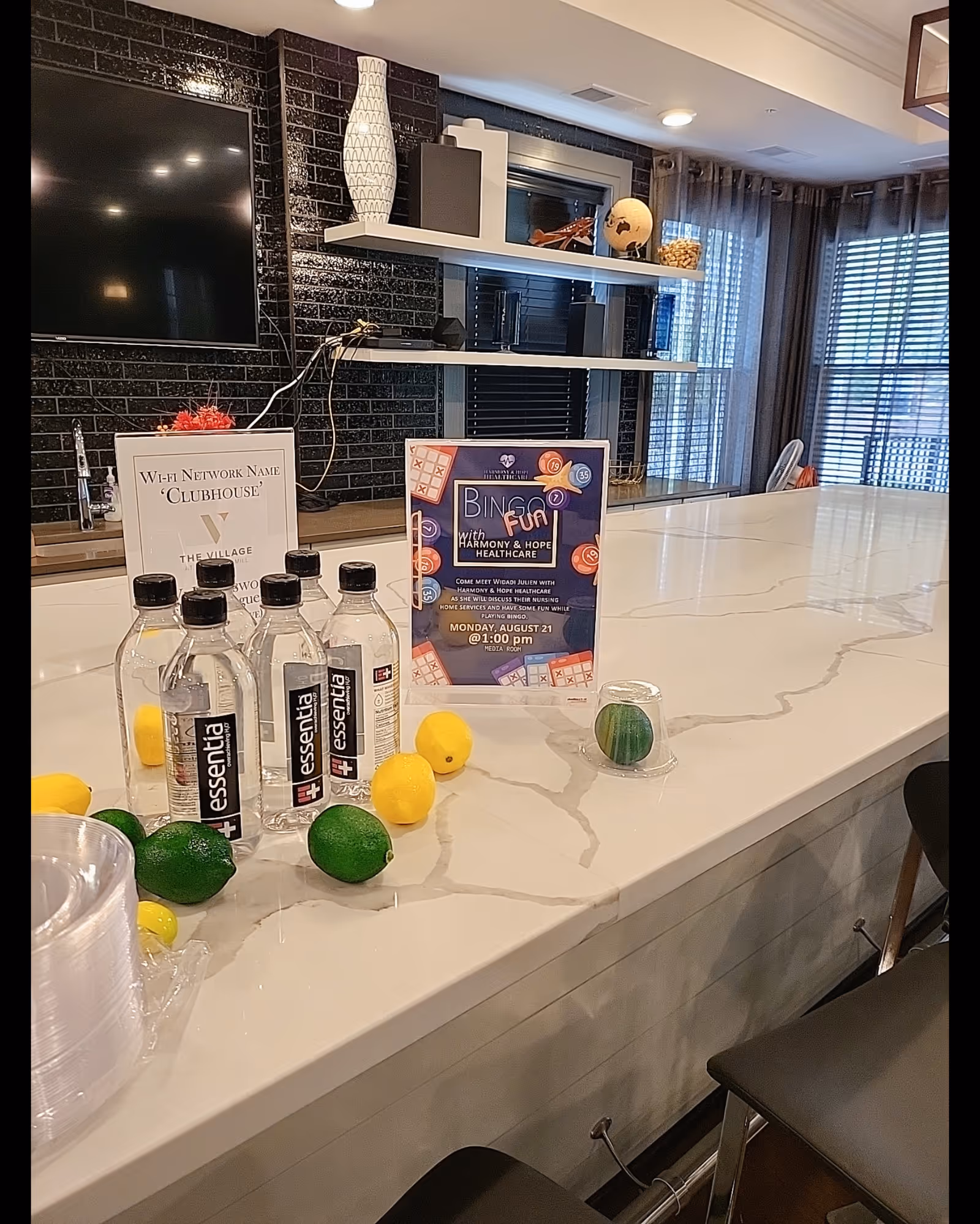Interior lounge counter with water bottles, citrus fruits, and a bingo event flyer.