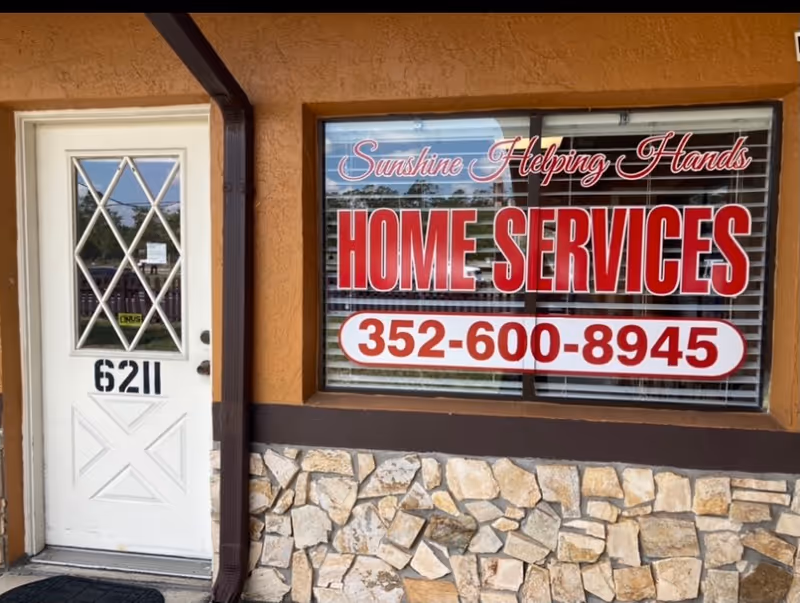 Exterior view of Sunshine Helping Hands building with a large red Home Services sign in window.