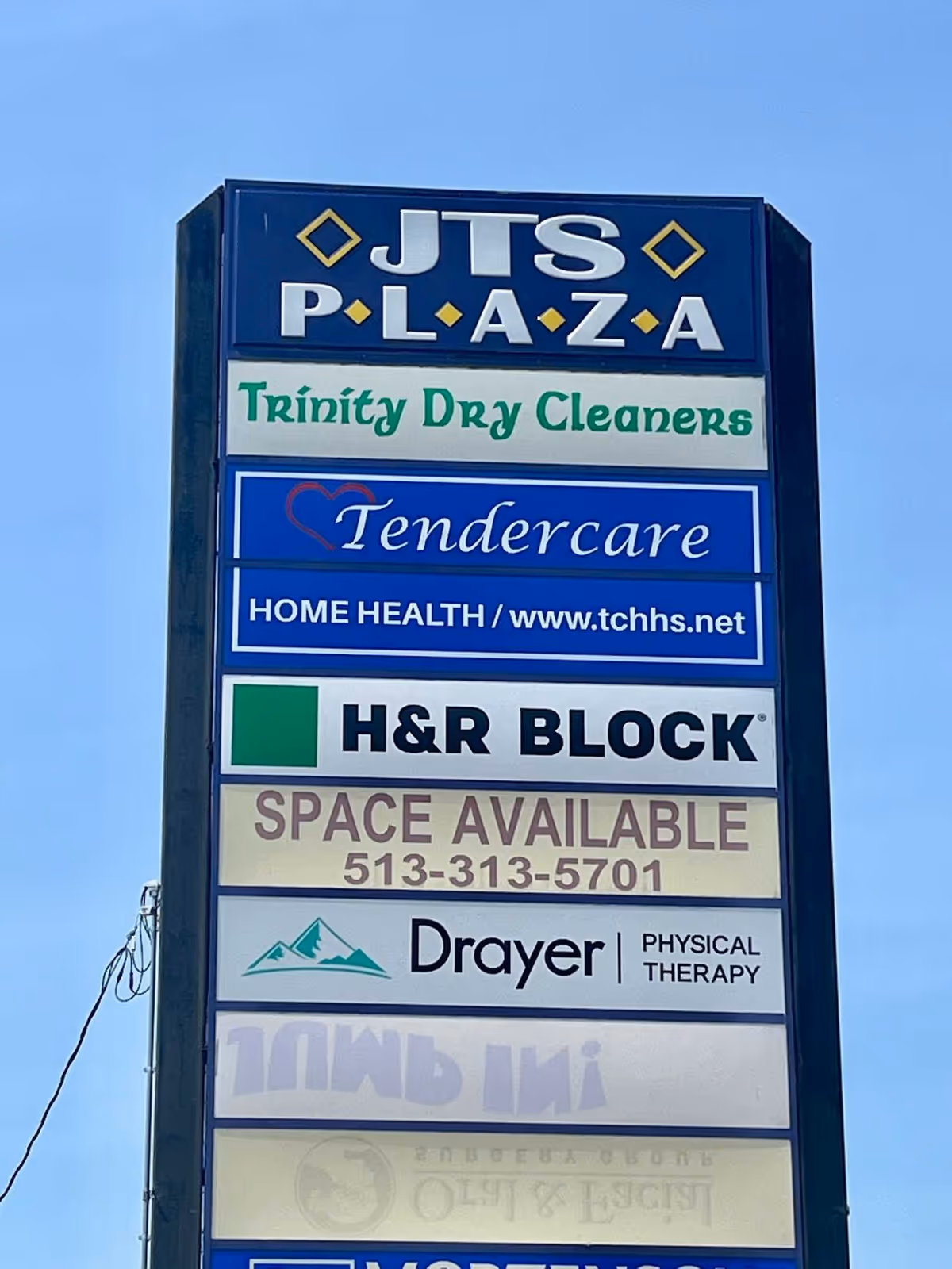 Tall outdoor signboard listing multiple businesses, including Tendercare Home Health Services.