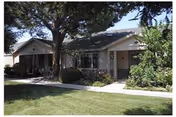 Single-story Brookside Senior Apartments building with front lawn, trees, and walkway.