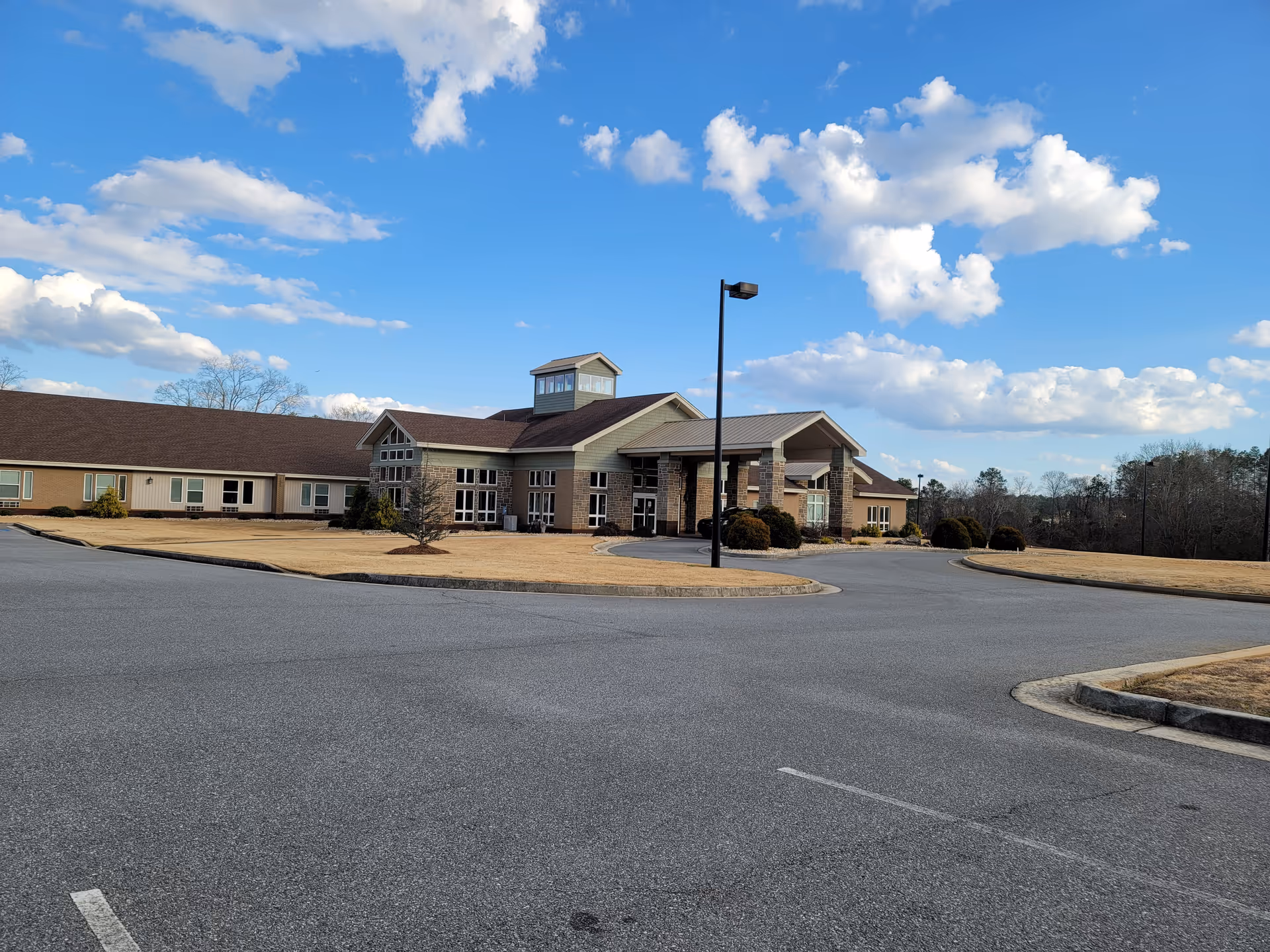 Exterior view of a Lodge senior living facility with circular driveway and covered entrance
