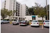 Front view of Mary Walker Towers with parked cars and trees.
