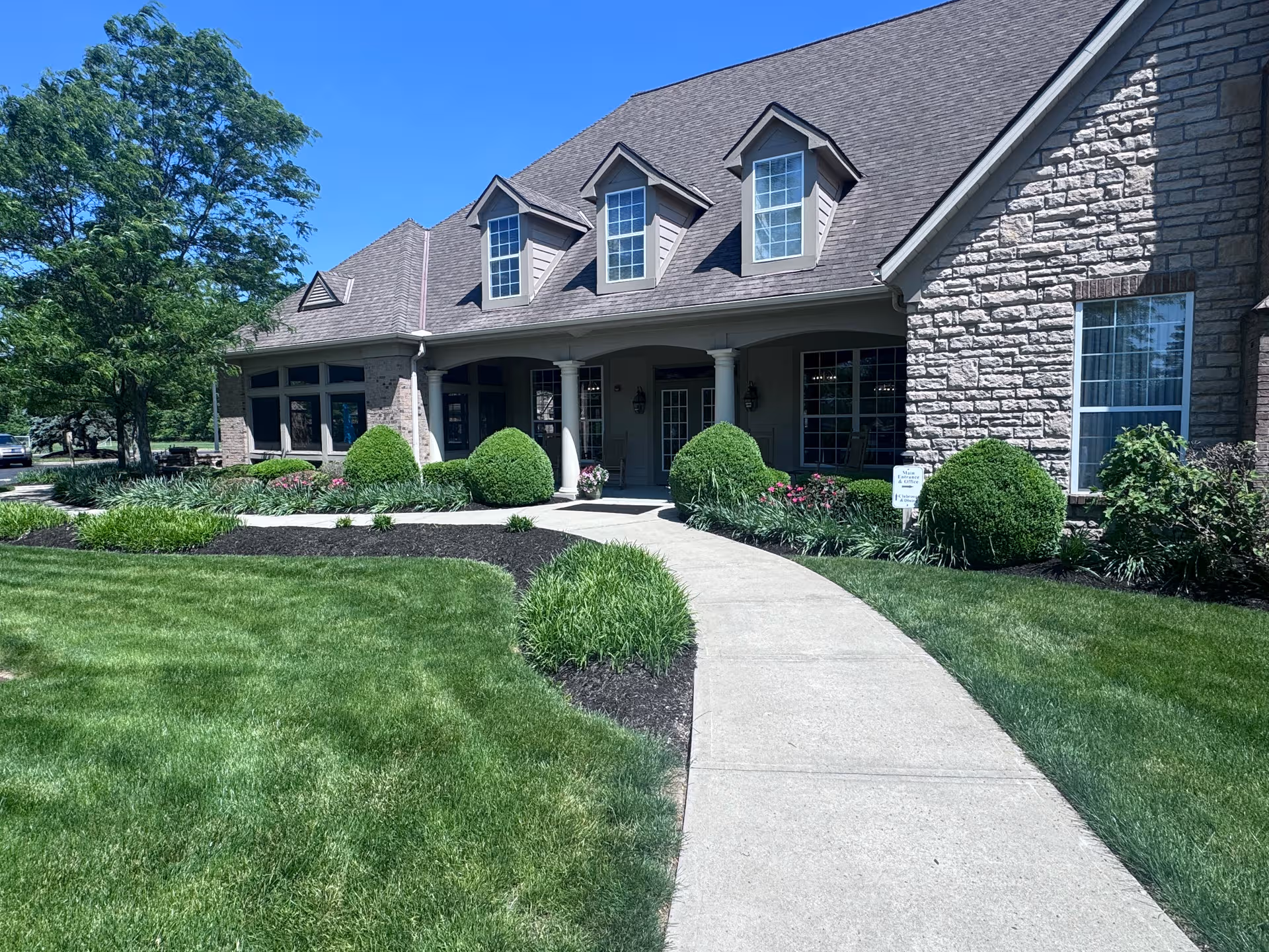 Front exterior of Feridean Commons senior living with walkway and landscaped lawn.