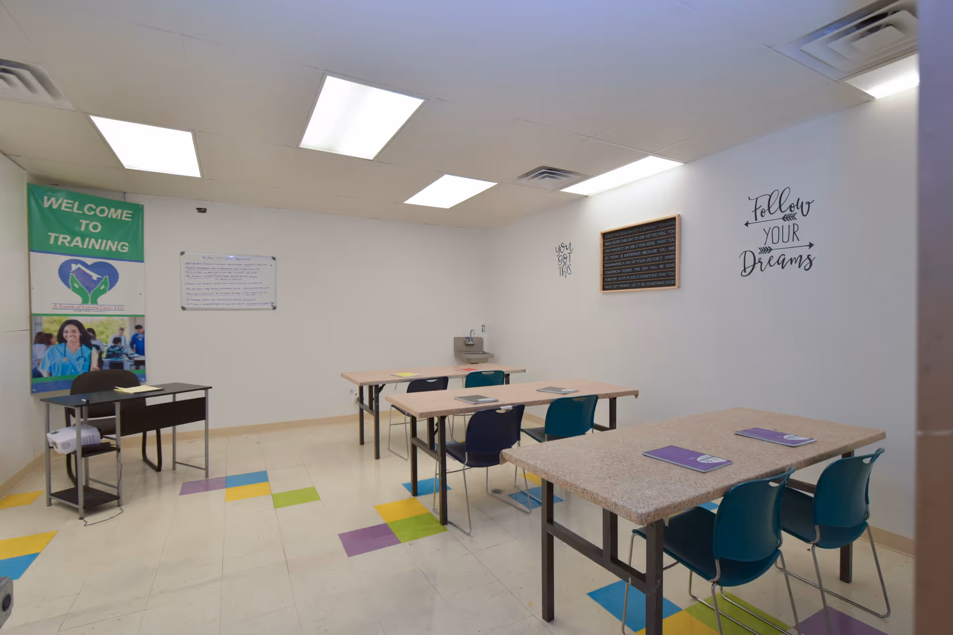 Training room in a senior care facility with tables, chairs, and decor.