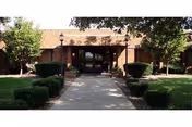 Marigold Rehabilitation Health Care Center entrance with a walkway and manicured shrubs.