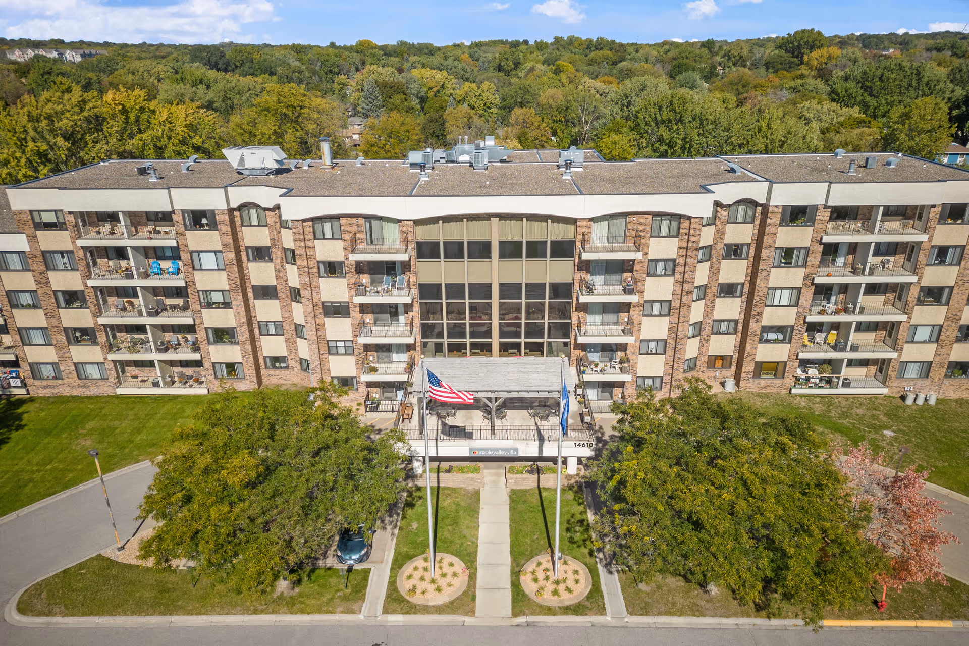 Aerial view of Apple Valley Villa exterior building with balconies, entrance, and flags