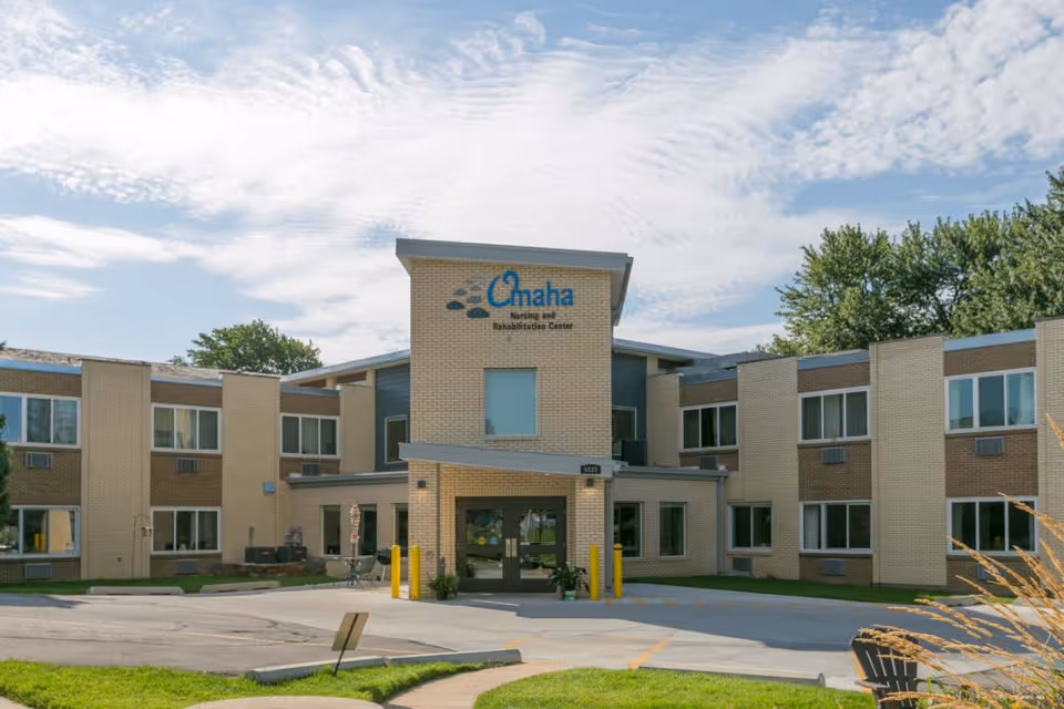 Front facade of Omaha Nursing and Rehabilitation Center building with entrance and parking.