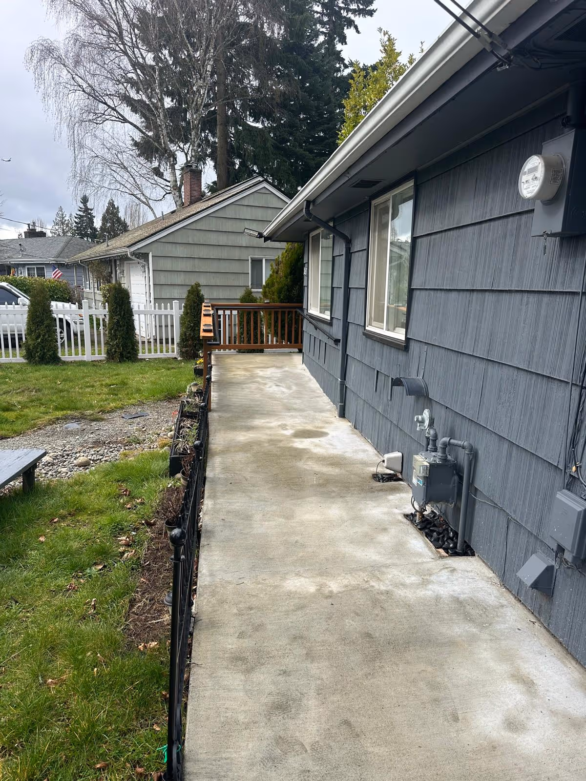 Exterior view of Care with Passion Adult Family Home showing a walkway beside blue siding.