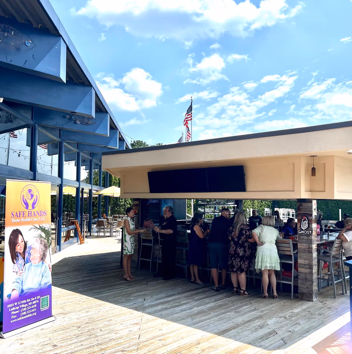 Outdoor patio at Safe Hands Home Health & Hospice with people gathered around a bar counter.