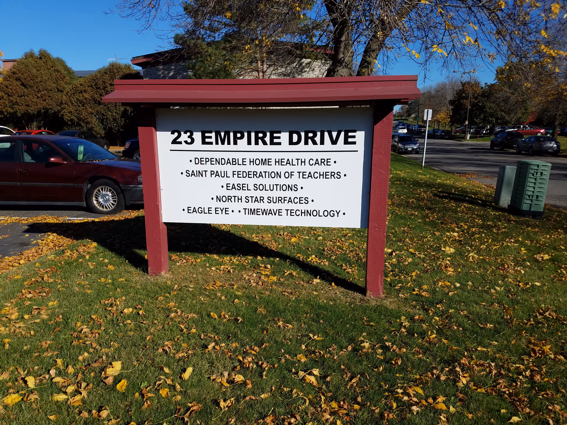 Outdoor sign reads 23 Empire Drive for Dependable Home Health Care near parked cars.