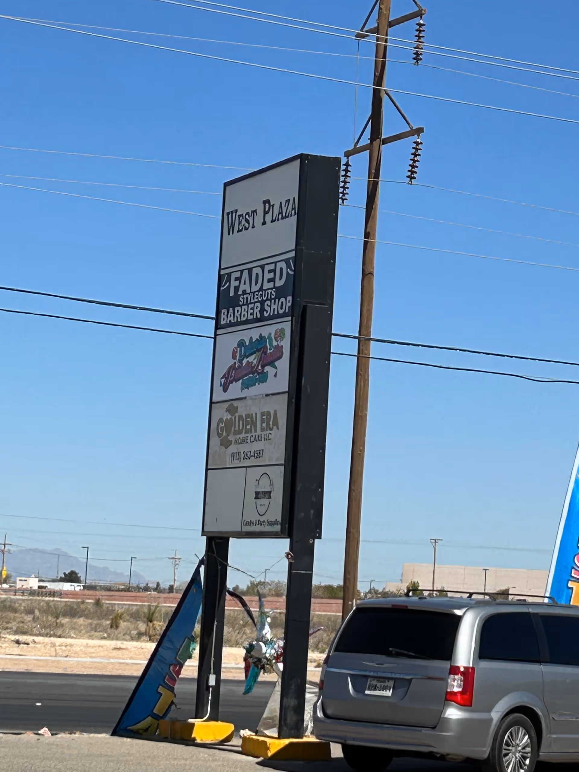 Tall roadside sign with Golden Era Home Care and West Plaza advertising in a parking lot.