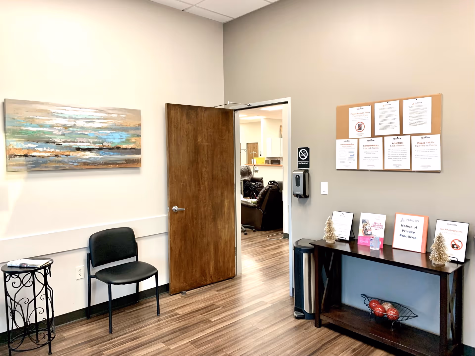 Interior lobby area with table, bulletin board, and doorway to treatment room.