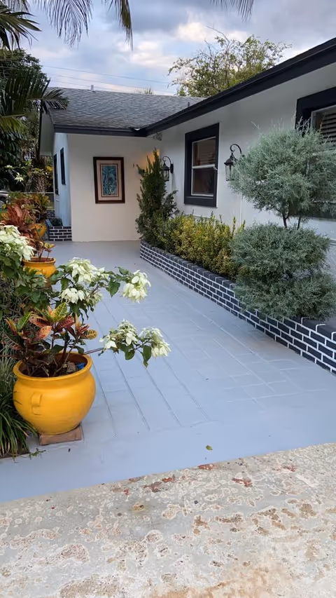 Exterior walkway with potted plants beside a single-story care facility.