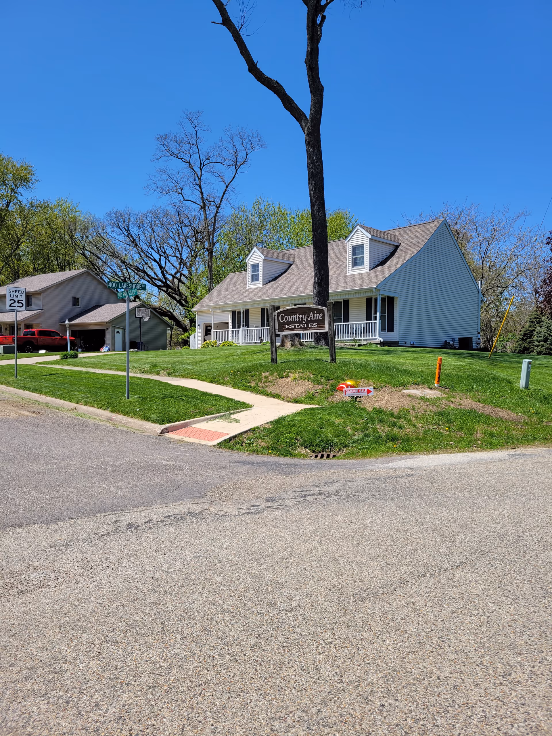 A single story senior living facility with a front lawn and a Country Aire Estates sign.