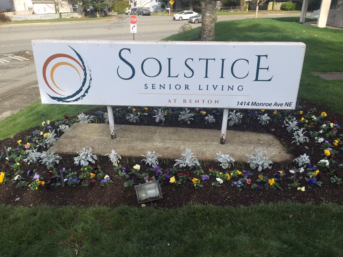 Solstice Senior Living at Renton sign with a flower bed and greenery.