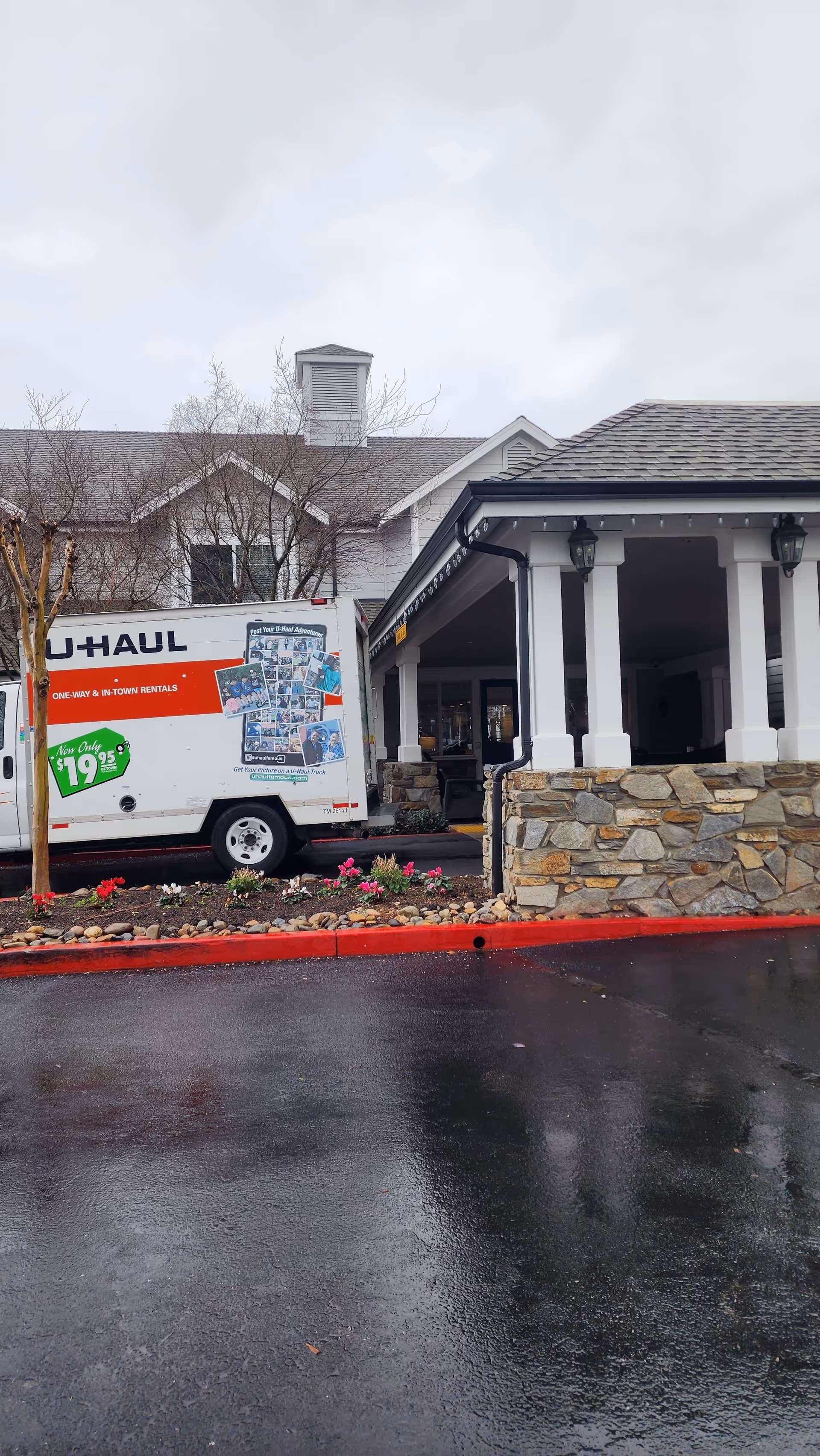 Exterior view of a senior living facility with a U-Haul truck by the entrance.