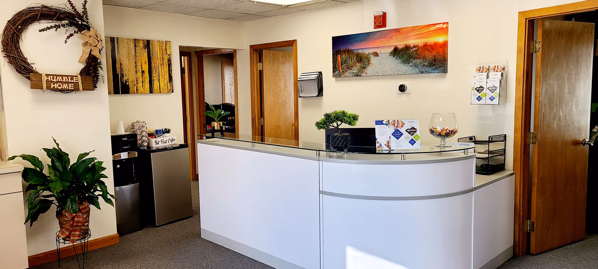 Reception desk in a Humble Home lobby with plants and wall art.