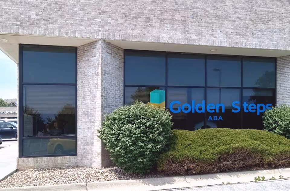 Brick building exterior with large windows and a blue Golden Steps ABA sign.