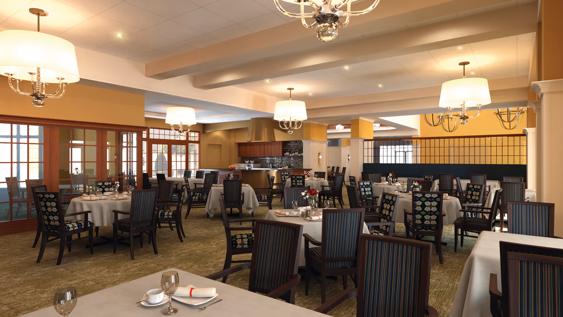 Spacious dining room with multiple round and rectangular tables set for meals, chandeliers, and a service counter in the background.